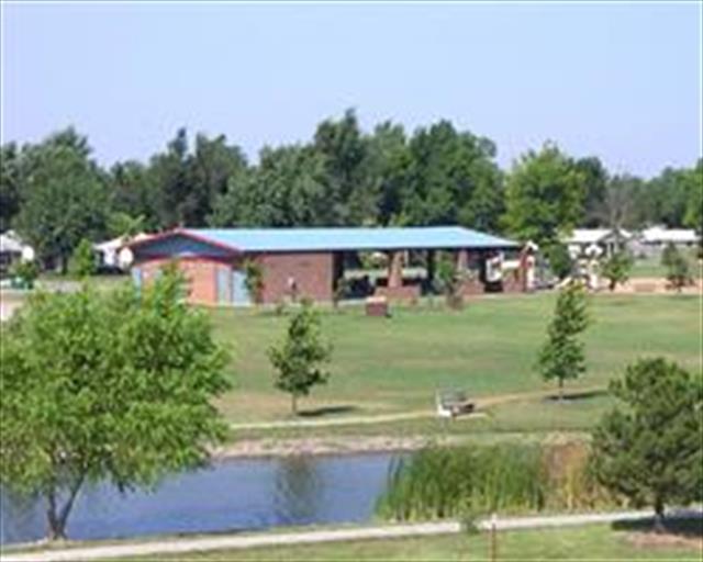A picturesque park showcasing a pond with trees lining the background.